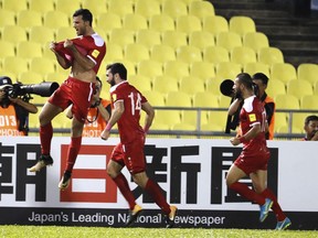 Syria's Firas Mohamad Alkhatib, left, celebrate after scoring goal during match against Australia during the 2018 World Cup qualifying football match between Syria and Australia at the Hang Jebat Stadium in Melaka, Malaysia, Thursday, Oct. 5, 2017. (AP Photo/Vincent Thian)