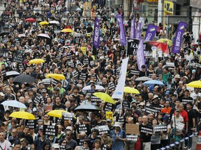 Protesters march in Hong Kong Sunday, Oct. 1, 2017. Pro-democracy groups held a protest against what they perceive as China's authoritarian rule and to demand the Secretary for Justice step down for what they believe is an eroding of the rule of law following new stiffer sentences for student protest leaders. (AP Photo/Vincent Yu)