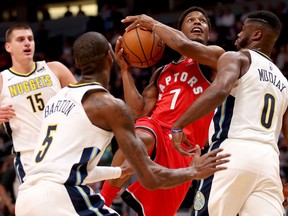 Kyle Lowry of the Toronto Raptors drives to the basket against Will Barton and Emmanuel Mudiay of the Nuggets at the Pepsi Center in Denver on Wednesday night.
