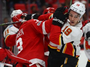 Matthew Tkachuk of the Flames gets a glove to the face from Nick Jensen of the  Red Wings during the third period at Little Caesars Arena in Detroit on Wednesday night.