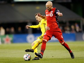 Pedro Santos of the Columbus Crew and Michael Bradley of Toronto FC battle for control of the ball during the first half Tuesday night at MAPFRE Stadium on in Columbus, Ohio.