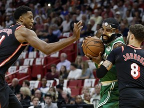 Boston Celtics' Kyrie Irving, center, drives as Miami Heat's Hassan Whiteside (21) and Tyler Johnson (8) defend during the first half of an NBA basketball game, Wednesday, Nov. 22, 2017, in Miami. (AP Photo/Lynne Sladky)