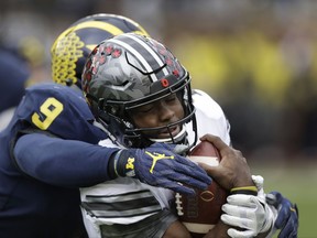 Ohio State quarterback J.T. Barrett (16) is sacked by Michigan linebacker Mike McCray (9) during the first half of an NCAA college football game, Saturday, Nov. 25, 2017, in Ann Arbor, Mich. (AP Photo/Carlos Osorio)