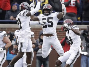 Ohio State running back Mike Weber (25) jumps with wide receiver Parris Campbell (21) and wide receiver Binjimen Victor (9) after Weber's touchdown during the second half of an NCAA college football game against Michigan, Saturday, Nov. 25, 2017, in Ann Arbor, Mich. Ohio State won 31-20. (AP Photo/Carlos Osorio)