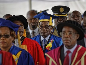 Zimbabwe's President Robert Mugabe, center, arrives to preside over a student graduation ceremony at Zimbabwe Open University on the outskirts of Harare, Zimbabwe Friday, Nov. 17, 2017. Mugabe is making his first public appearance since the military put him under house arrest earlier this week. (AP Photo/Ben Curtis)