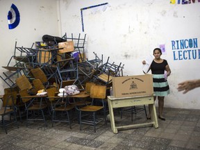 A woman prepares to casts her vote after filling out her ballot during the general elections in Tegucigalpa, Honduras, Sunday, Nov. 26, 2017. Honduran President Juan Orlando Hernandez tries to win a second term as well as bolstering the strength of his conservative National Party across the board. (AP Photo/Rodrigo Abd)