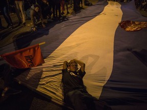 A supporter of presidential candidate Salvador Nasralla rests on a Honduran flag during a protest in Tegucigalpa, Honduras, Wednesday, Nov. 29, 2017.  The opposition candidate says he will not recognize an official vote count by the country's electoral court and is alleging manipulation of Sunday's election. (AP Photo/Rodrigo Abd)