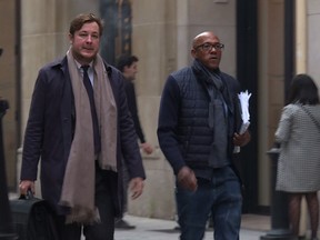 An image grab from an AFP TV video shows International Olympics Committee member Frankie Fredericks, right, arriving at the financial crimes court building in Paris on Nov. 2, 2017.