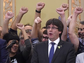 This file photo taken on October 27, 2017 shows then Catalan regional president Carles Puigdemont (C) singing the Catalan anthem "Els Segadors" after a Catalan parliament session in Barcelona.