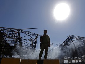 A Houthi fighter inspects the site of an air strike in the Yemeni capital Sanaa, on November 5, 2017.