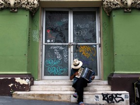 A man plays his accordion in front of a closed down business in Old San Juan, Puerto Rico on November 7, 2017.