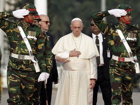 Pope Francis reviews a honor guard as he arrives at Dhaka's international airport, Bangladesh, Thursday, Nov. 30, 2017. (AP Photo/Andrew Medichini)