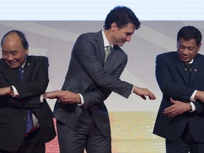 Canadian Prime Minister Justin Trudeau shakes hands with Vietnamese Prime Minister Nguyen Xuan Phuc and Philippine President Rodrigo Duterte during a photo for the ASEAN-Canada 40th Commemorative session in Manila, Philippines, Tuesday, November 14, 2017. THE CANADIAN PRESS/Adrian Wyld