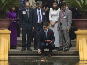 Canadian Prime Minister Justin Trudeau stops to feed the fish after touring the Ho Chi Minh stilt house in Hanoi, Vietnam Wednesday November 8, 2017. THE CANADIAN PRESS/Adrian Wyld