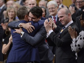 Prime Minister Justin Trudeau hugs Veteran's Affairs Minister Seamus O'Regan after making a formal apology to individuals harmed by federal legislation, policies, and practices that led to the oppression of and discrimination against LGBTQ2 people in Canada, in the House of Commons in Ottawa, Tuesday, Nov.28, 2017. THE CANADIAN PRESS/Adrian Wyld