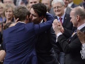 Prime Minister Justin Trudeau hugs Veteran's Affairs Minister Seamus O'Regan after making a formal apology to individuals harmed by federal legislation, policies, and practices that led to the oppression of and discrimination against LGBTQ2 people in Canada, in the House of Commons in Ottawa, Tuesday, Nov.28, 2017. THE CANADIAN PRESS/Adrian Wyld