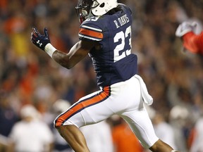 Auburn wide receiver Ryan Davis jumps over Georgia linebacker Natrez Patrick scoring a touchdown during the second half of an NCAA college football game, Saturday, Nov. 11, 2017, in Auburn, Ala. Auburn won 40-17. (AP Photo/Brynn Anderson)