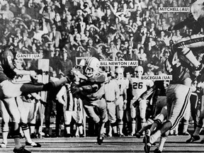 FILE - In this Dec. 2, 1972, file photo, Auburn's Bill Newton, center, blocks an Alabama  puns in the fourth quarter of the Iron Bowl NCAA college football game at Legion field in Birmingham, Ala., that resulted in an Auburn touchdown. (Haywood Paravicini/AL.com via AP, File)