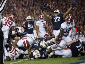 Auburn running back Kerryon Johnson (21) reaches over the goal line for the go-ahead touchdown against Alabama during the Iron Bowl NCAA football game Saturday, Nov. 25, 2017, in Auburn, Ala. Auburn won 26-14. (Albert Cesare/The Montgomery Advertiser via AP)