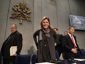 Vatican Museum director Barbara Jatta, center arrives with Monsignor Paolo Nicolini, left, and Zhu Jiancheng, secretary general China Culture Industrial Investment Fund, right, for a press conference at the Vatican, Tuesday, Nov. 21, 2017. The Vatican and China have announced a first-ever exchange of artworks for exhibits in Beijing and the Vatican Museums, as the two states forge ahead with soft diplomacy amid a stalemate in negotiations to heal decades of diplomatic estrangement. (AP Photo/Alessandra Tarantino)