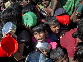 A Rohingya Muslim girl cries as she waits squashed against other children to receive food handouts distributed to children and women by a Turkish aid agency at Thaingkhali refugee camp in Ukhiya, Bangladesh, Tuesday, Nov. 14, 2017. U.N. Secretary-General Antonio Guterres expressed alarm over the plight of Rohingya Muslims in remarks before Myanmar's Aung San Suu Kyi and other leaders from a Southeast Asian bloc that has refused to criticize her government over the crisis.(AP Photo/A.M. Ahad)