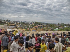 Rohingya Muslims, who crossed over from Myanmar into Bangladesh, wait in queues to receive aid at Kutupalong refugee camp in Ukhiya, Bangladesh, Wednesday, Nov. 15, 2017.