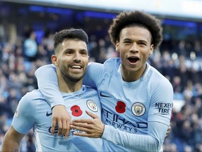 Manchester City's Sergio Aguero, left, celebrates scoring his side's second goal of the game with teammate Leroy Sane, during the English Premier League soccer match between Manchester City and Arsenal, at the Etihad Stadium, in Manchester, Sunday, Nov. 5, 2017. (Martin Rickett/PA via AP)