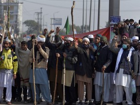 Supporters of Pakistani radical religious party hold sticks while chanting slogans close to the site of sit-in protest at an intersection of Islamabad, Pakistan, Saturday, Nov. 18, 2017. A government deadline set for an Islamic group to disband its days long rally in Pakistan's capital has expired, but authorities extended it for 24 hours to avoid a crackdown. (AP Photo/Anjum Naveed)