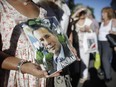 In this Jan. 18, 2017 file photo, a person holds a photo of late prosecutor Alberto Nisman during a demonstration on the second-year anniversary of his death in Buenos Aires, Argentina.
