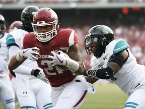 Arkansas running back Devwah Whaley pushes past Costal Carolina defender Eric Church, right, to score a touchdown during the first half of an NCAA college football game Saturday, Nov. 4, 2017, in Fayetteville, Ark. (AP Photo/Michael Woods)