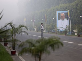 A Bangladeshi man takes a selfie with a portrait of Pope Francis displayed along a route the Pope is expected to take during his visit, in Dhaka, Bangladesh, Thursday, Nov. 30, 2017. Pope Francis is expected to arrive in Bangladesh Thursday on the second leg of his weeklong South Asia tour. (AP Photo/Aijaz Rahi)