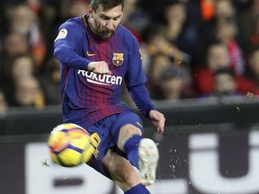 Barcelona's Lionel Messi shoots the ball during the Spanish La Liga soccer match between Valencia and FC Barcelona at the Mestalla stadium in Valencia, Spain, Sunday, Nov. 26, 2017. (AP Photo/Alberto Saiz)