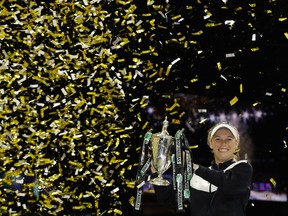 In this Sunday, Oct. 29, 2017, file photo, Caroline Wozniacki of Denmark lifts the winner's trophy after winning the singles final match against Venus Williams of the United States, at the WTA tennis tournament in Singapore. (AP Photo/Yong Teck Lim, File)
