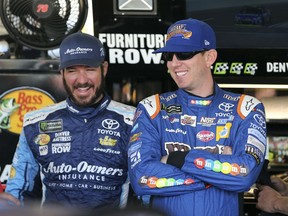 Kyle Busch, right, and Martin Truex Jr. laugh inside the garage area before practice for the NASCAR Cup Series auto race at Phoenix International Raceway, Friday, Nov. 10, 2017, in Avondale, Ariz. Both drivers have secured a spot in the Championship 4 heading into Sunday's race. (AP Photo/Ralph Freso)