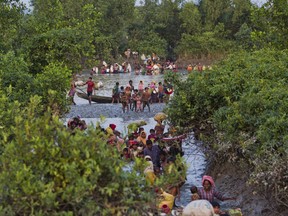 Groups of Rohingya Muslims cross the Naf river at the border between Myanmar and Bangladesh, near Palong Khali, Bangladesh, Wednesday, Nov. 1 2017. On Wednesday at least 2,000 exhausted and starving Rohingya crossed the swollen Naf river and waited along the border for permission to cross. It's a scene that's played out over and over again with heartbeaking regularity as hundreds of thousands of Rohingya Muslims have fled persecution in Myanmar and escaped to neighboring Bangladesh. (AP Photo/Bernat Armangue)