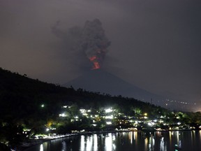 A view of the Mount Agung volcano erupting in Karangasem, Bali, Indonesia, Monday, Nov. 27, 2017. Indonesia authorities raised the alert for the rumbling volcano to highest level on Monday and closed the international airport on the tourist island of Bali stranding thousands of travelers.