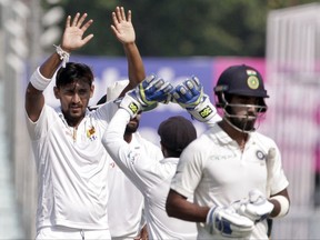 Sri Lanka's Suranga Lakmal, left, celebrates the dismissal of India's Lokesh Rahul, right, during the fifth day of their first test cricket match in Kolkata, India, Monday, Nov. 20, 2017. (AP Photo/Bikas Das)
