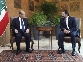In this photo released by the Lebanese Government, Lebanese President Michel Aoun, left, meets with Prime Minister Saad Hariri, at the Presidential Palace in Baabda, east of Beirut, Lebanon, Wednesday, Nov. 22, 2017. Hours after returning to the country following a nearly three week puzzling absence, Hariri participated in Independence Day celebrations Wednesday, his first official appearance since he suddenly announced his resignation from abroad, stunning the country. (Dalati Nohra/Lebanese Government via AP)
