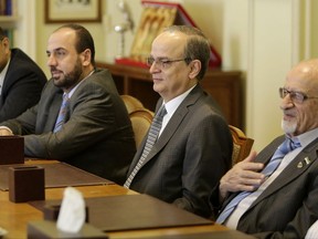 FILE -- In this Sept. 8, 2014 file photo, members of the Syrian Coalition (SNC), Syria's main political opposition group, Haitham al-Maleh, right, Hadi Bahra, the head of the coalition, second right, and Nasr al-Hariri, Secretary-General of the SNC, meet with Arab League Secretary-General Nabil Elaraby at the league's headquarters in Cairo, Egypt. Syria's opposition is gathering in Saudi Arabia hoping to close ranks ahead of new negotiations starting Wednesday, Nov. 22, 2017, but they are a house divided in ways that enhance Syrian President Bashar Assad's upper hand. Hours before the meeting, a dozen opposition figures resigned.  (AP Photo/Amr Nabil, File)