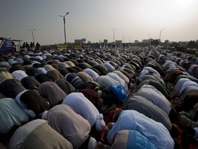 Protesters offer prayers during a sit-in protest at an entrance of Islamabad, Pakistan, Friday, Nov. 17, 2017. Pakistani police have warned an Islamist rally to disband within hours to avoid a crackdown near the capital, where an estimated 5,000 members of a radical Islamic party have camped out and disrupted life. (AP Photo/B.K. Bangash)