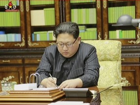This image made from video of a news bulletin aired by North Korea's KRT on Nov. 29, 2017, shows an image of North Korea's leader Kim Jong Un signing what is said to be a document on Nov. 28, 2017, authorizing a missile test. After two and a half months of relative peace, North Korea launched its most powerful weapon yet early Wednesday, claiming a new type of intercontinental ballistic missile that some observers believe could put Washington and the entire eastern U.S. seaboard within range. Independent journalists were not given access to cover the event depicted in this photo. (KRT via AP Video)
