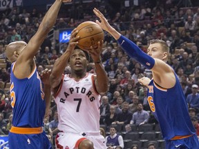 Raptors guard Kyle Lowry drives to the basket between the New York Knicks' Kristaps Porzingis (6) and Jarrett Jack (55) during first half NBA action at the Air Canada Centre in Toronto on Friday night.