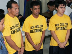 FILE - In this Monday, Nov. 19, 2007, file photo, left to right; from right, suspects Adnam Kusain, Ikram Indama and Caidar Aunal linked to the blast at the House of Representatives are lined up at the Department of Justice in Manila, Philippines. from right, Adnam Kusain, Ikram Indama and Caidar Aunal. A Philippine court has convicted Indama of multiple murders in the motorcycle bomb attack that killed a Muslim rebel-turned-congressman and three other people and wounded 10, including two legislators. Kusain and Aundal were acquitted of their charges in the case. (AP Photo/Bullit Marquez, FIle)