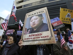 FILE - In this Monday, Nov. 6, 2017, file photo, an anti-North Korea protester holds up a portrait of North Korean leader Kim Jong Un during a rally welcoming the visit by U.S. President Donald Trump near the U.S. Embassy in Seoul, South Korea.North Korea is on its way back onto a very short list of countries the United States says sponsor terrorism. The designation will expand the already substantial array of sanctions the U.S. has imposed on trade with North Korea. (AP Photo/Ahn Young-joon, File)