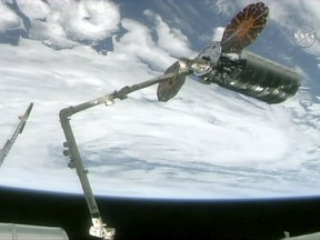 The International Space Station's robotic arm captures the Cygnus cargo spacecraft, Tuesday, Nov. 14, 2017, 260 miles  (418 kms.) above the earth. The commercial supply ship arrived at the International Space Station on Tuesday, two days after launching from Virginia. (NASA TV via AP)