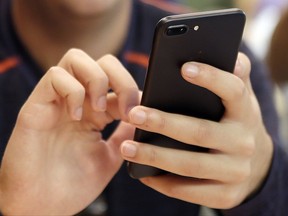 FILE - In this Friday, Sept. 16, 2017, file photo, a person uses a smart phone in Chicago. A new analysis suggests that increased social media use could be one factor contributing to a rise in teen suicide. (AP Photo)