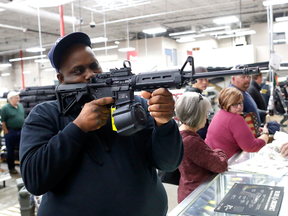 Ronnie Noble checks out a firearm on sale in Gainesville, Fla.,  Friday Nov. 24, 2017.