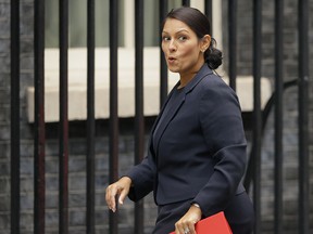 In this Tuesday, Oct. 10, 2017 file photo, Britain's Secretary of State for International Development Priti Patel reacts to a question from the media as she arrives for a cabinet meeting at 10 Downing Street in London.