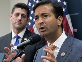 FILE - In this Oct. 24, 2017 file photo, Rep. Carlos Curbelo, R-Fla., right, stands with Speaker of the House Paul Ryan, R-Wis., left, discussing the GOP agenda for tax reform during a news conference on Capitol Hill in Washington. Curbelo is one of two people who will be honored with the John F. Kennedy New Frontier Awards, Thursday evening, Nov. 16, 2017, at Harvard University's Kennedy School of Government in Cambridge, Mass. (AP Photo/J. Scott Applewhite, File)