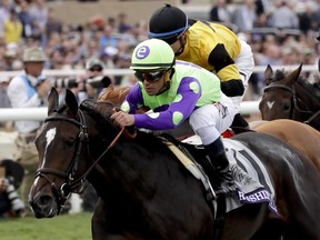Jockey Javier Castellano rides Rushing Fall to victory in the Juvenile Fillies Turf horse race during the first day of the Breeders' Cup, Friday, Nov. 3, 2017, in Del Mar, Calif. (AP Photo/Gregory Bull)